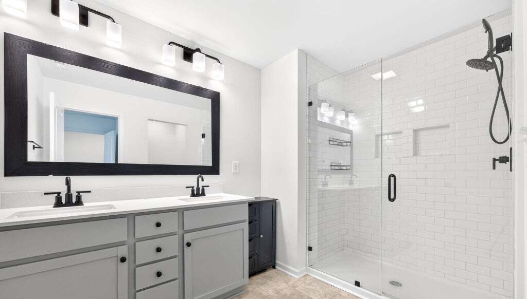 Primary bathroom with double vanity and glass shower
