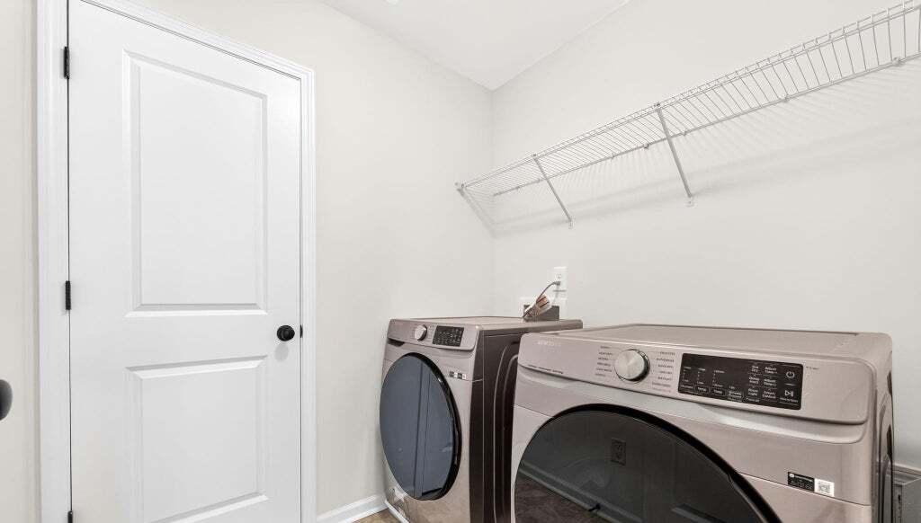 Upstairs laundry room with stacked washer and dryer